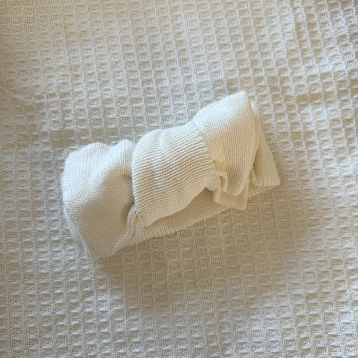 White knitted bow accessory with curled loop and ribbed center