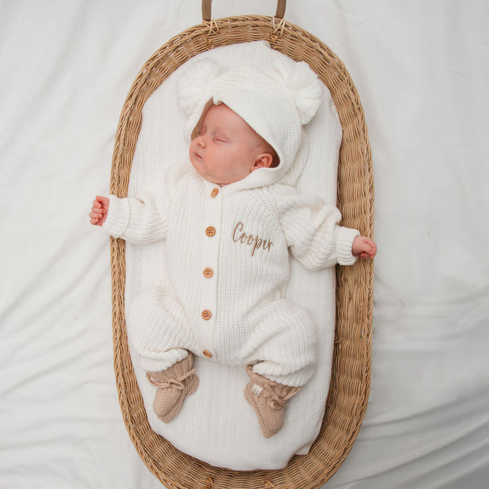 White knitted pom pom romper set with hood, long sleeves, button front, and socks style feet