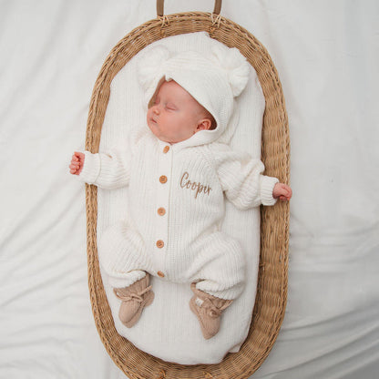 White knitted pom pom romper set with hood, long sleeves, button front, and socks style feet