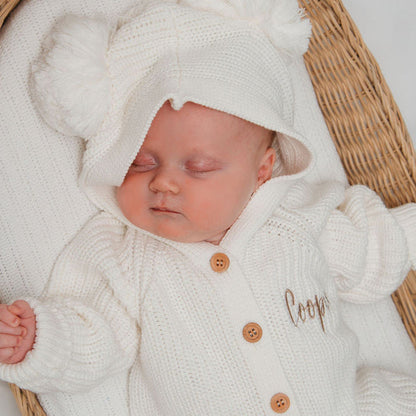 White knit baby romper with hood and button front, featuring name embroidery on chest