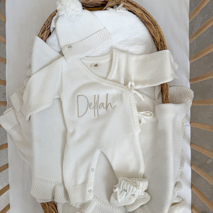 White long romper with Delilah name embroidery and buttoned leg openings