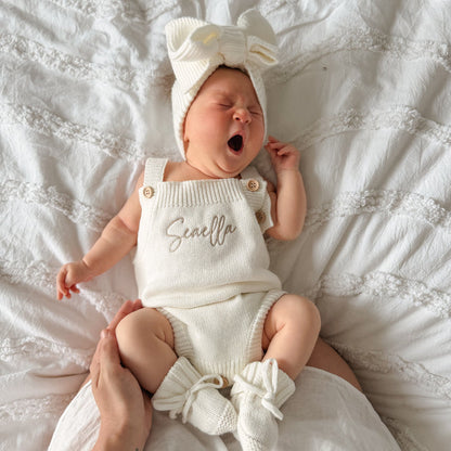 White knit personalised romper with front script name, bow top and ruffle leg cuffs