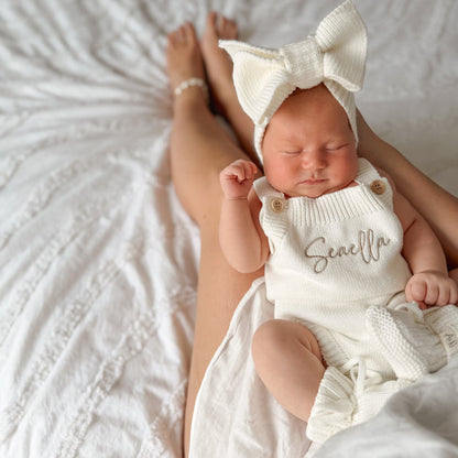 White knit personalised romper with front script name, short straps and snap buttons