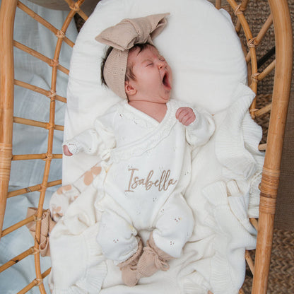White pointelle kimono romper with embroidered “Isabella” name and ruffled trim along edges.