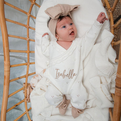 White pointelle kimono romper with “Isabella” embroidery, wide crossover neckline, and long sleeves.